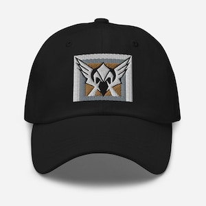 May include: Black baseball cap with an embroidered white and gold emblem featuring a winged helmet.
