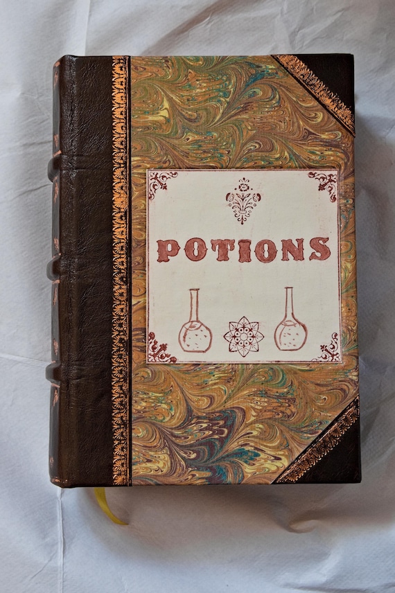 A legitimately gorgeous half-bound leather journal dressed up as an alchemist's spellbook — the kind of thing you'd find in a wizard's study.