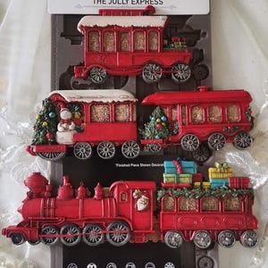 May include: A red and white Christmas train mould for crafting. The mould is made of silicone and is 5 inches by 10 inches. The mould is designed to create a three-dimensional train with a locomotive, a passenger car, and a caboose. The mould is perfect for creating Christmas decorations, ornaments, or gifts.