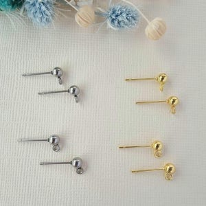 May include: Four pairs of earring findings, two pairs are silver and two pairs are gold. Each pair has a small ball at the end of the post.