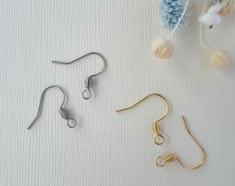 May include: Two pairs of earring hooks, one silver and one gold. The hooks are made of metal and have a spring-loaded closure.