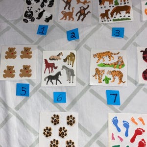 May include: A set of 11 sheets of stickers featuring various animal designs. The stickers include pandas, monkeys, horses, bears, tigers, paw prints, and footprints. The stickers are on a white background and are numbered 1 through 11.