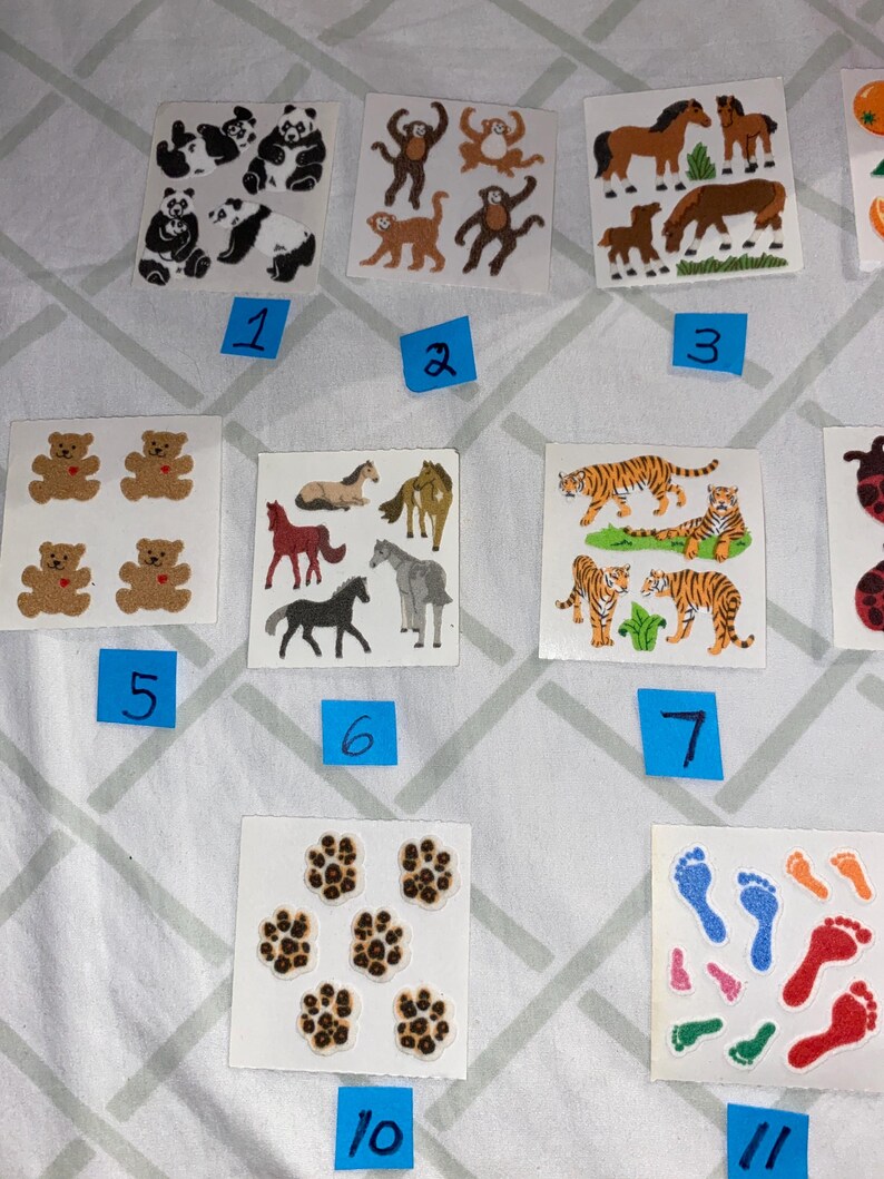 May include: A set of 11 sheets of stickers featuring various animal designs. The stickers include pandas, monkeys, horses, bears, tigers, paw prints, and footprints. The stickers are on a white background and are numbered 1 through 11.