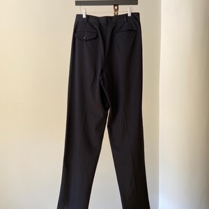 K&ouml;nnte beinhalten: Schwarze, ma&szlig;geschneiderte Hose mit einer einzigen Ges&auml;&szlig;tasche und einem Knopfverschluss.