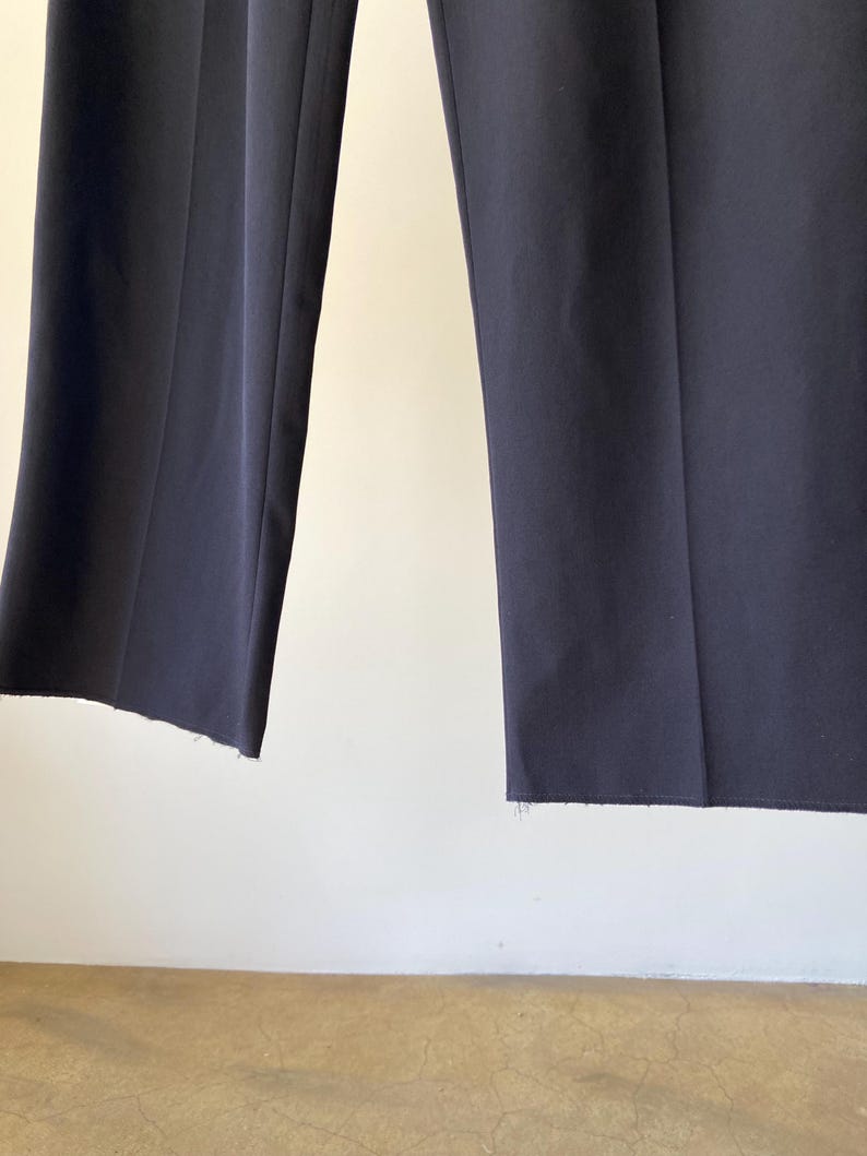 K&ouml;nnte beinhalten: Eine dunkelblaue Hose mit einem rohen Saum.