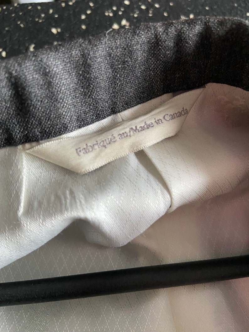 May include: A white label with black text that reads "Fabriqu&eacute; au/Made in Canada" attached to a black and white patterned fabric.