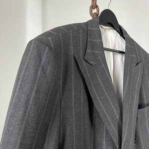 May include: A gray double-breasted blazer with thin vertical stripes.