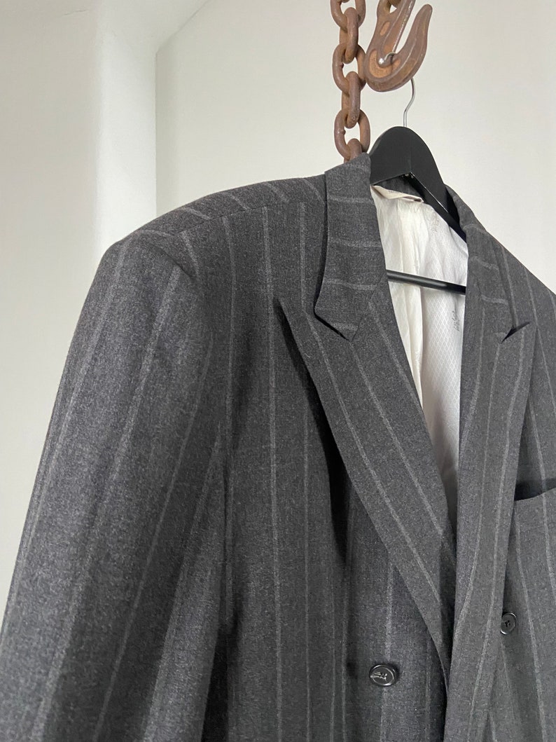 May include: A gray double-breasted blazer with thin vertical stripes.