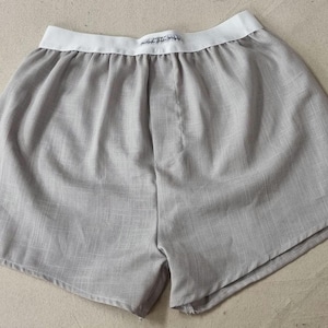 May include: Grey cotton boxer shorts with a white elastic waistband.