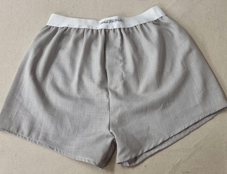 May include: Grey cotton boxer shorts with a white elastic waistband.