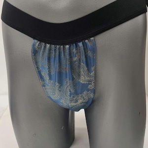 May include: A blue and gold patterned undergarment with a black elastic waistband.