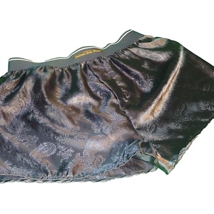 May include: Black satin shorts with a paisley pattern and a dark green elastic waistband.