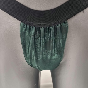 May include: Green satin underwear with a paisley pattern and a black elastic waistband.
