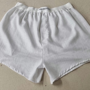 May include: White cotton boxer shorts with a white elastic waistband.