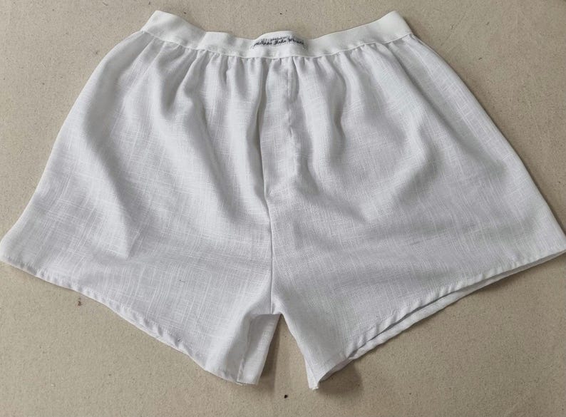 May include: White cotton boxer shorts with a white elastic waistband.