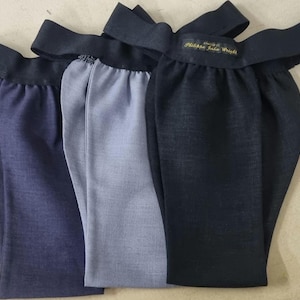Puede incluir: Tres corbatas de tela en azul marino, azul claro y negro. La corbata negra tiene una etiqueta dorada que dice "Philadelphia Ladies' Wear".