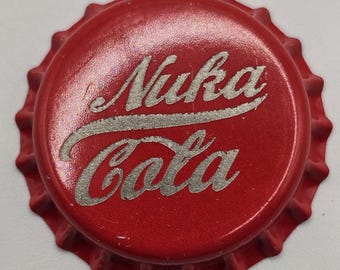 May include: Red bottle cap with the words "Nuka Cola" in silver lettering.