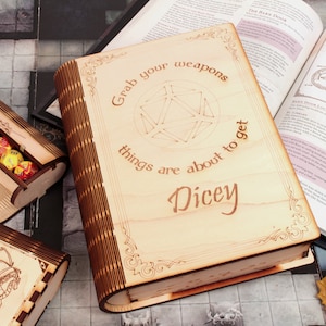 Chwyć broń, sprawy zaraz się skomplikują: Drewniana wieża do kości z hasłem Dungeon Master. Książka typu pop-up DnD dla Ciebie Book Nook.