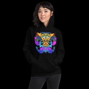 May include: Black hoodie featuring a vibrant, colorful graphic of a mythical creature. The design includes yellow, blue, purple, and pink elements, creating a striking visual contrast. The hoodie has a classic kangaroo pocket and a drawstring hood.