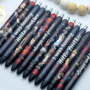 Pu&ograve; includere: Un set di dieci penne nere con glitter e accenti di glitter rosso. Ogni penna ha un'immagine e un testo diversi. Il testo sulle penne include "I was feeling", "Hello Brother" e "always and forever".