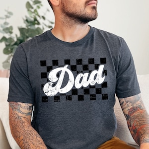 Camiseta estilo retro con estampado a cuadros en blanco y negro, diseño moderno y estético, con efecto desgastado.