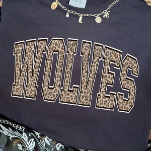Lobos con estampado de leopardo, estilo universitario, PNG desgastado, mascota de equipo escolar, diseño de camiseta de moda
