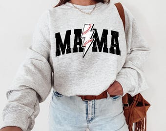 Könnte beinhalten: Ein grauer Pullover mit einem schwarzen Grafikdruck eines Blitzes mit einem Baseball darin. Der Text "MAMA" ist in Schwarz über dem Grafikdruck gedruckt.