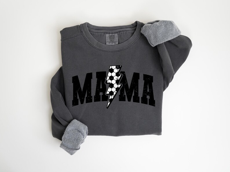 May include: A charcoal grey sweatshirt with a black and white lightning bolt graphic and the word "MAMA" in black block letters.