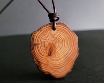 Colar artesanal com pingente de fatia de madeira de lariço reciclada e acabamento natural.