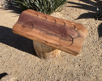 Könnte beinhalten: Ein Holztablett mit sechs runden Vertiefungen für Schnapsgläser. Das Tablett ist mit dem Text "Take life with a grain of salt and a shot of tequila" graviert.
