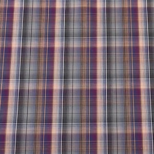 Può includere: Primo piano di un tessuto a quadri con un motivo ripetuto di linee intersecanti. Il tessuto presenta un mix di colori, tra cui viola, grigio, nero e beige. Le linee creano un design a griglia, adatto per abbigliamento o arredamento.