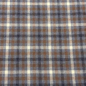 May include: Close-up of a fabric with a plaid pattern. The design features a grid of intersecting lines in brown, navy blue, and off-white. The fabric has a textured appearance, suggesting a woven material.