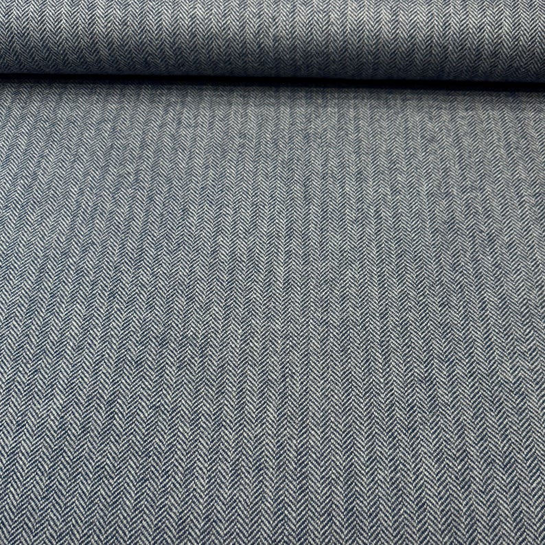 Gesamtansicht eines Fischgrät-Schurwoll-Tweeds in Blau und Grau. Die hochwertige Schurwolle aus deutscher Produktion macht diesen Stoff ideal für warme Blazer, leichte Mäntel, Capes und Jacken.