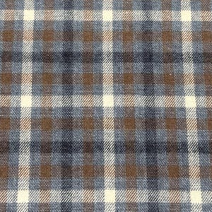 May include: Close-up of a fabric with a plaid pattern. The design features a grid of intersecting lines in cream, brown, and shades of blue. The fabric has a textured appearance, suggesting a woven material.