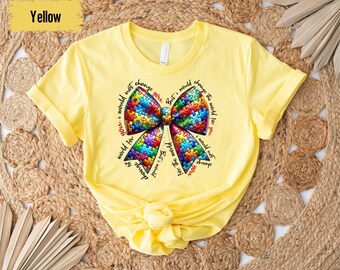 May include: Yellow t-shirt with a colorful puzzle piece bow and the text "Show the world not change you. But I would change the world for you. Show the world not change you. But I would change the world for you."