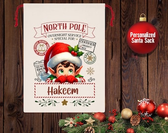 May include: A personalized Santa sack with a red and white elf illustration. The sack has the text "North Pole Overnight Service Special For: Hakeem" and a "Certified Naughty Nice" checklist.