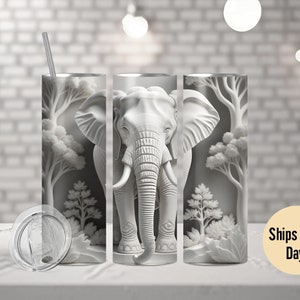 May include: White stainless steel tumbler with a white elephant design and a white tree design. The tumbler has a clear lid and a straw.