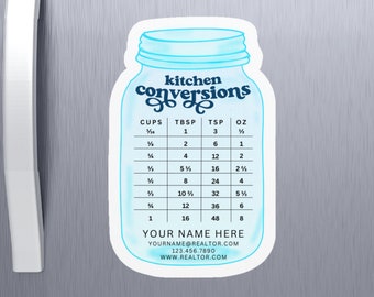 May include: A light blue kitchen conversions magnet in the shape of a mason jar. The magnet displays a conversion chart for cups, tablespoons, teaspoons, and ounces. The text "kitchen conversions" is at the top. The bottom of the magnet has contact information.