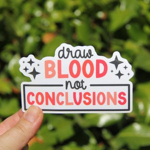 May include: A white sticker with the text "draw BLOOD not CONCLUSIONS" in red and black. The sticker has a black border and is decorated with four black star shapes.
