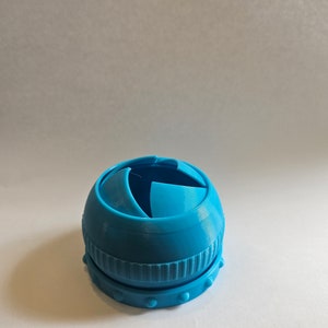 以下が含まれることがあります： セグメント状の開口部のある青いプラスチック製の球体。球体はテクスチャ加工されたベースを持っています。