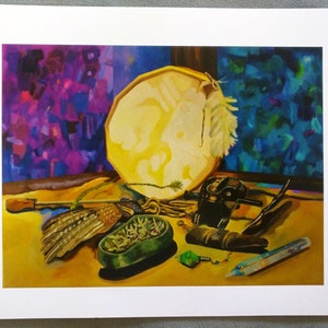 May include: A still life painting depicting a round, white drum with a feather attached, a small bird with brown and white feathers, a green bowl with green and brown contents, a black object with a silver knob, a brown wooden object, a green crystal, and a clear crystal with a silver chain.