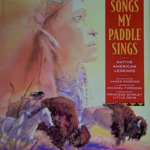 May include: Book cover illustration for "The Songs My Paddle Sings." The image features a Native American profile, a warrior on horseback, and bison. The title is in large gold letters on a red background.