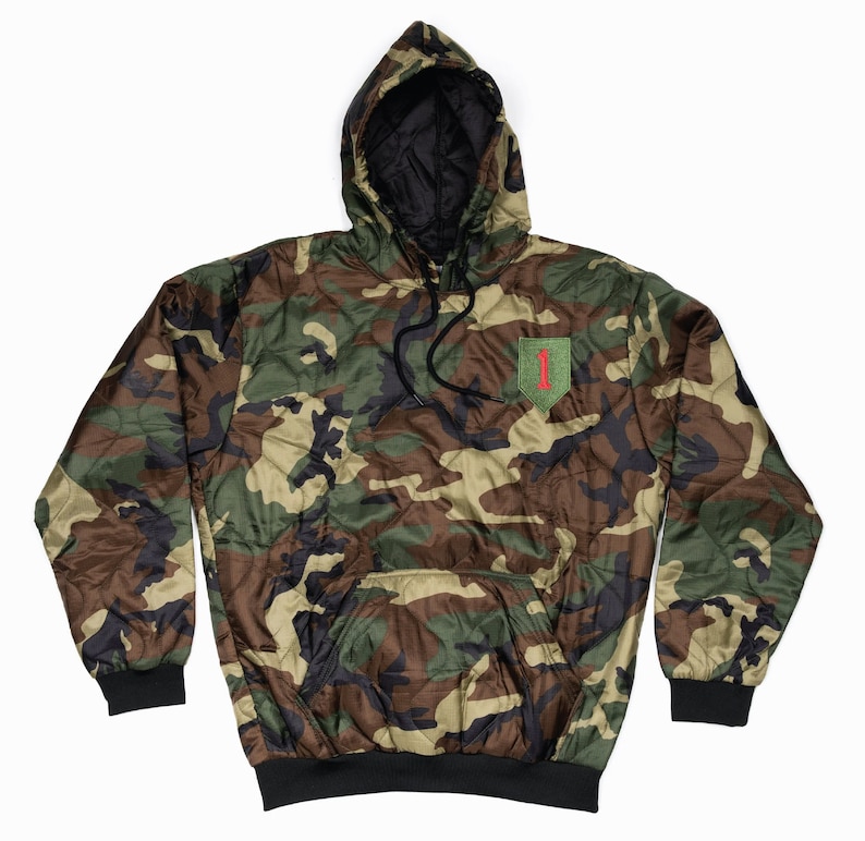 May include: A camouflage hooded sweatshirt with a black lining and a green patch with a red "1" on the left chest.