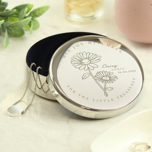 May include: Silver keepsake box with a floral design and the inscription "Mia Joy Mitchell Daisy April 10.04.1989 For the Little Treasures".