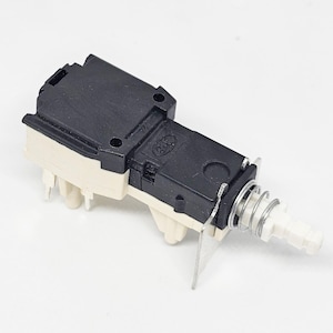 Può includere: Un interruttore elettrico bianco e nero con un meccanismo a molla e una manopola in plastica bianca. L'interruttore ha un alloggiamento in plastica nera e una base in plastica bianca.