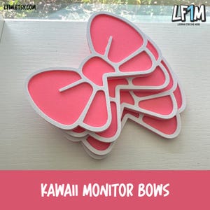 May include: Pink and white monitor bows stacked on a white surface. The bows have a layered design with a pink center and white outline. The text "KAWAII MONITOR BOWS" is at the bottom of the image.