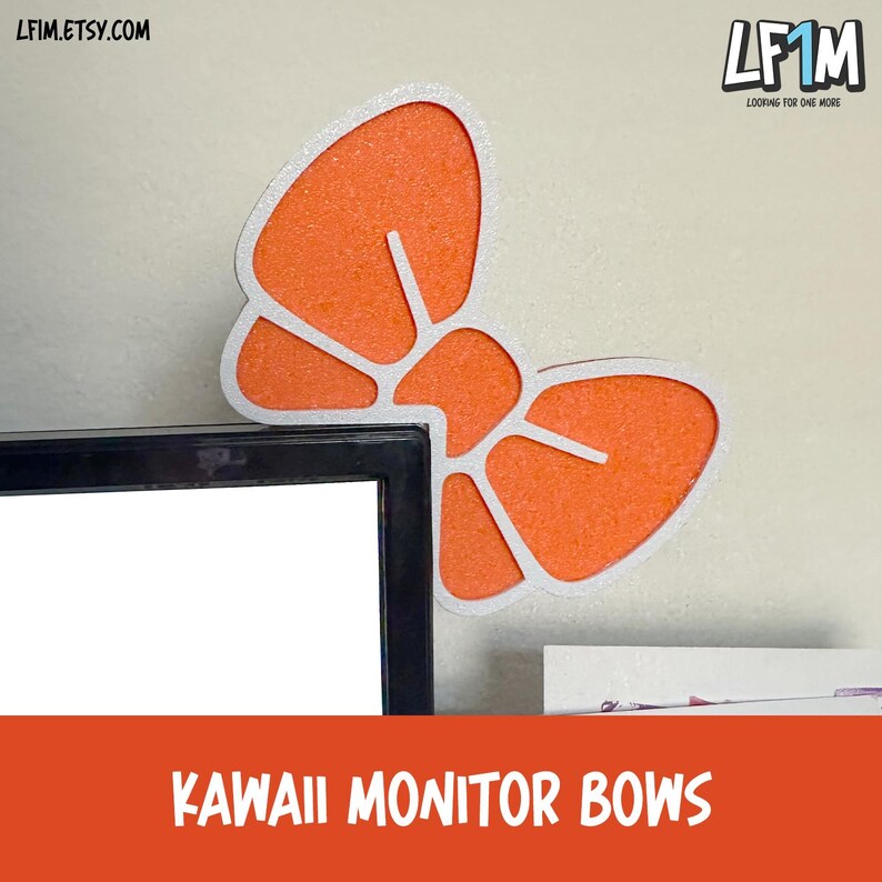 May include: An orange and white bow-shaped monitor decoration. The bow is made of a textured orange material with a white outline. The text "KAWAII MONITOR BOWS" is displayed on an orange banner.