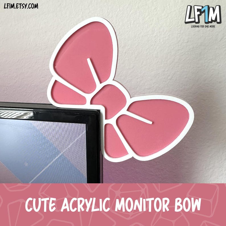 May include: A pink acrylic bow-shaped monitor decoration with a white outline. The bow is mounted on the corner of a computer monitor. The text "CUTE ACRYLIC MONITOR BOW" is displayed at the bottom of the image.