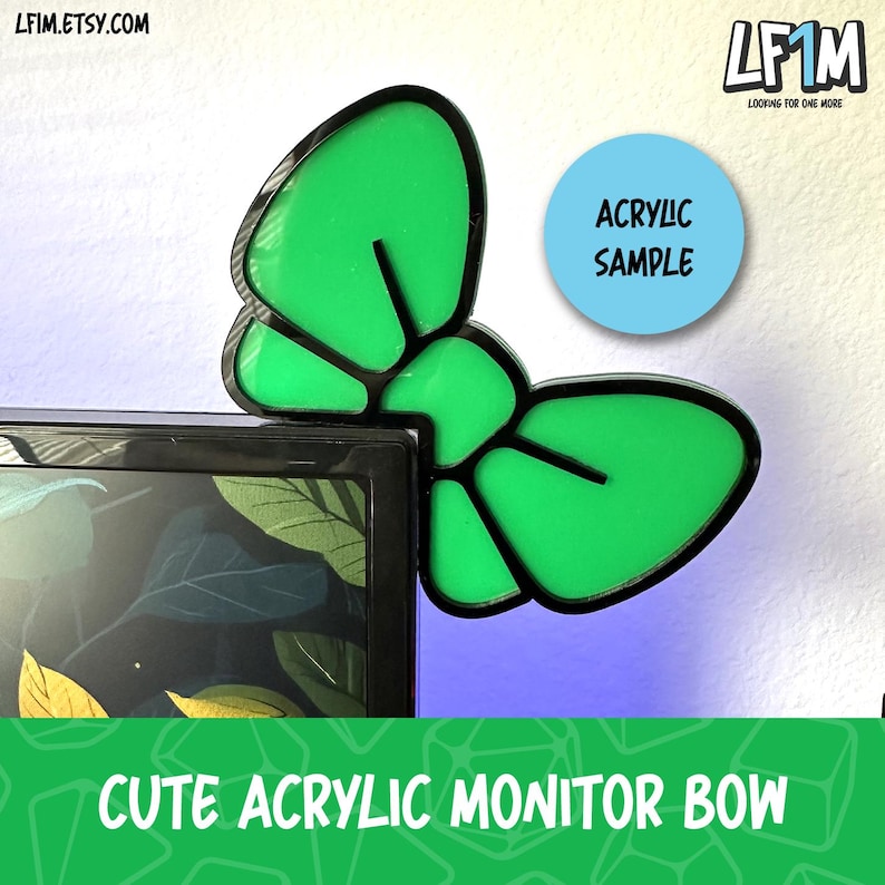 May include: A green acrylic monitor bow in a butterfly shape with a black outline. The text "Acrylic Sample" is on a light blue circle. The bottom of the image has the text "Cute Acrylic Monitor Bow".
