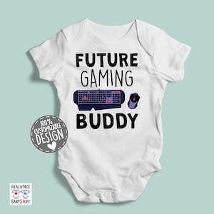 May include: White baby bodysuit with the text "Future Gaming Buddy" in black. A keyboard and mouse are pictured above the text.